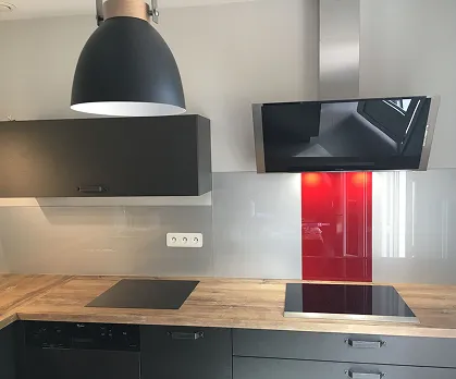 Cuisine moderne avec hotte noire et crédence rouge