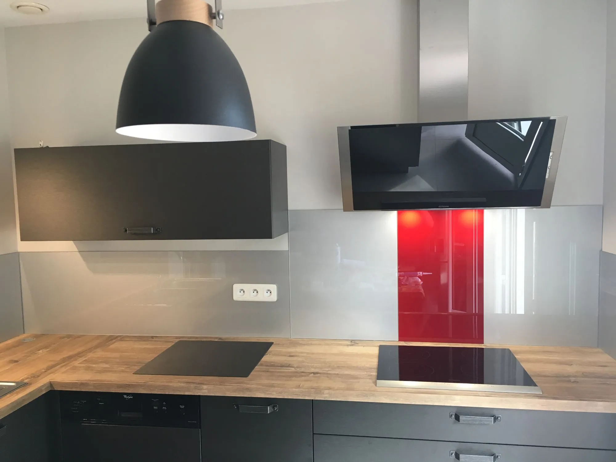 Cuisine moderne avec hotte noire et crédence en verre